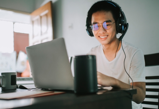 A happy smiling student working at home