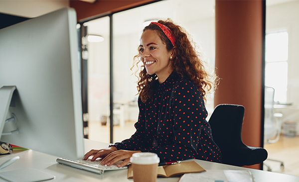 A tutor smiling and typing on a keyboard